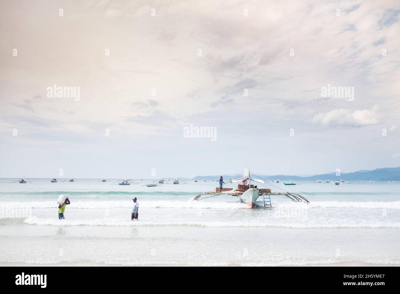 Juli 2017. Arbeiter laden Grundnahrungsmittel wie Reis und Zucker auf Boote, um sie in ihre Dörfer zurückzubringen. Sabong Beach, Puerto Princesa, Palawan, Philippinen. Stockfoto