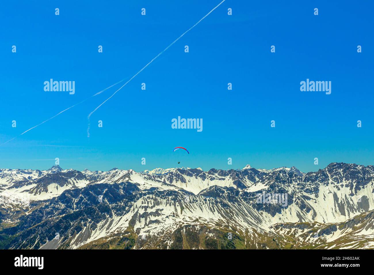 Bergparagliding am blauen Himmel des Aroser Weisshorn, Ferienort in der Schweiz. Draufsicht auf die Bergstation der Plessurer Alpen Stockfoto
