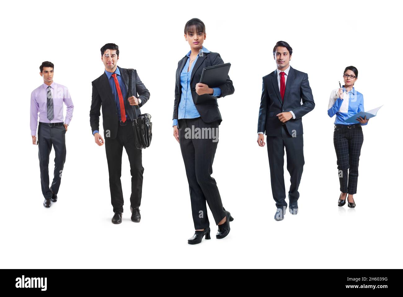 Ein Team von Unternehmensmitarbeitern, die in formeller Kleidung vor weißem Hintergrund in sozialer Distanz stehen. Stockfoto