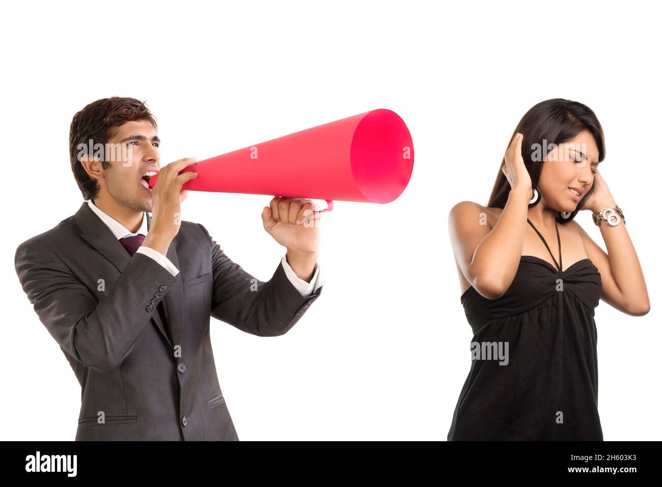 Ein Firmenangestellter in einem formellen Geschäftsanzug, der mit einem Lautsprecher in die Ohren der Sekretärin ruft. Stockfoto