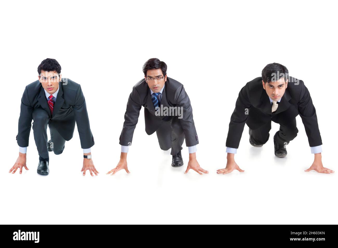 Eine Gruppe männlicher Unternehmensmitarbeiter in formellen Geschäftsbereichen ist im Begriff, ein Rennen zu führen. Stockfoto
