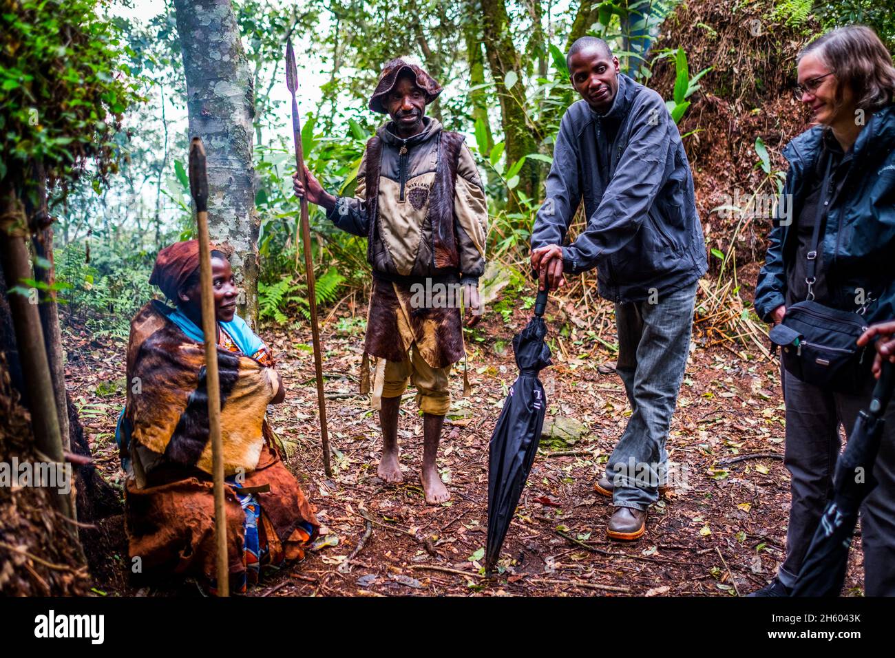 September 2017. Der Guide Phillip Byarugaba arbeitet für die Nkuringo Community Conservation and Development Foundation (NCCDF), die die Buniga Community Forest Trail Tour veranstaltet. Phillip übersetzt für den Batwa-Führer, der seine Kultur in seiner Landessprache teilt. Die Batwa Pygmäen wurden Anfang der 1990er Jahre aus ihrem Heimatland im Wald vertrieben, als die Nationalparks gegründet wurden, was sie landlos und arm in einer Gesellschaft hinterließ, die sie als eine niedrigere Klasse betrachtete. Heute versuchen einige von ihnen, durch die Durchführung von Wanderwegen zu treffen; kulturelle Touren, die Beispiele enthalten, wo und wie sie zu leben in der verwenden Stockfoto