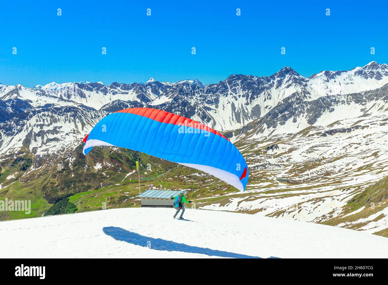 Aroser Weisshorn, Kanton Graubünden, Schweiz - Juni 2021: Man Paragliding auf dem Gipfel des Aroser Weisshorns in der Schweiz. Draufsicht auf die Plessurer Alpen Stockfoto