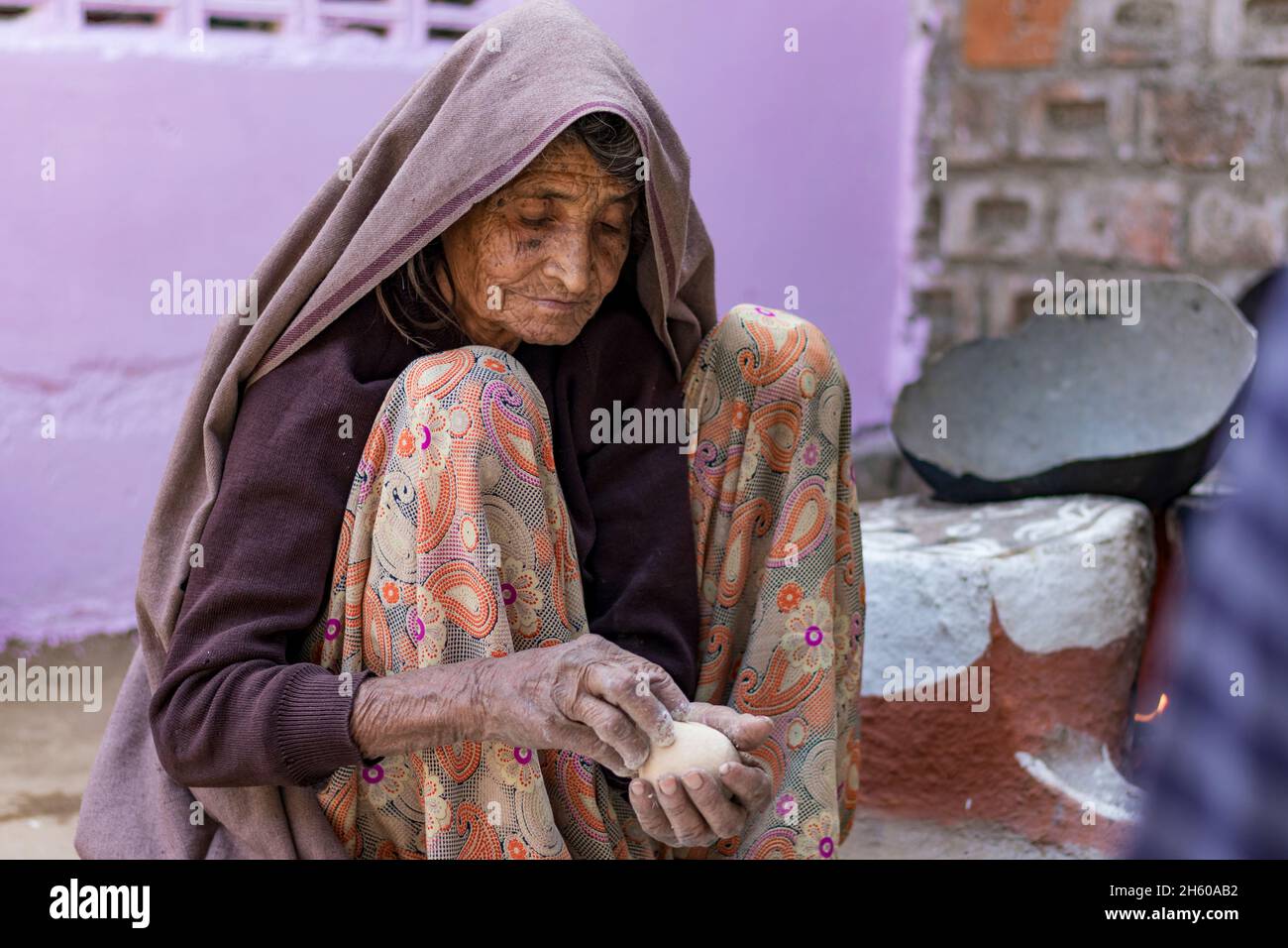 Eine indische Frau im hohen Alter, die in rajasthan, indien, Lebensmittel für die Familie macht Stockfoto