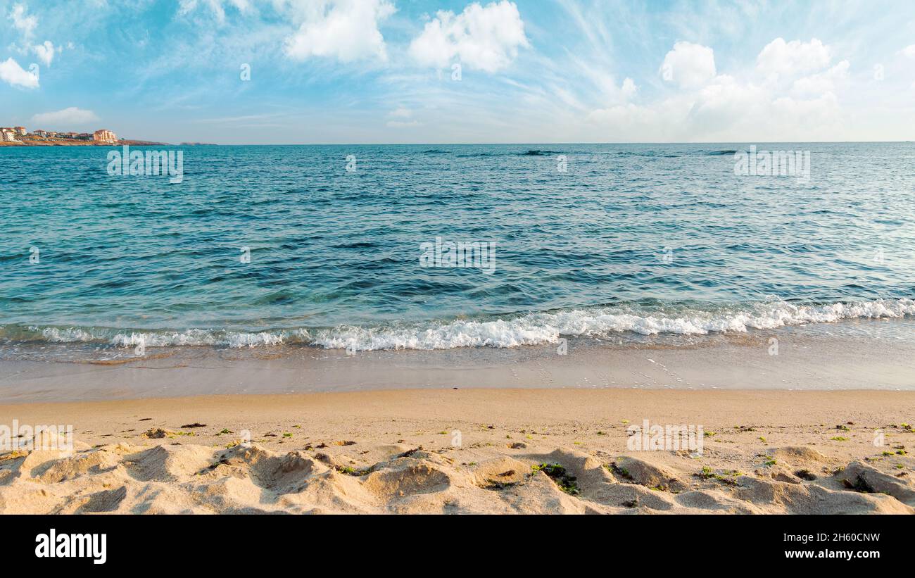 Ruhige Morgenlandschaft am Meer. Leerer Sandstrand im Morgenlicht. Entspannung und Sommerurlaubskonzept. Sonniges Wetter mit Wolken am Himmel Stockfoto