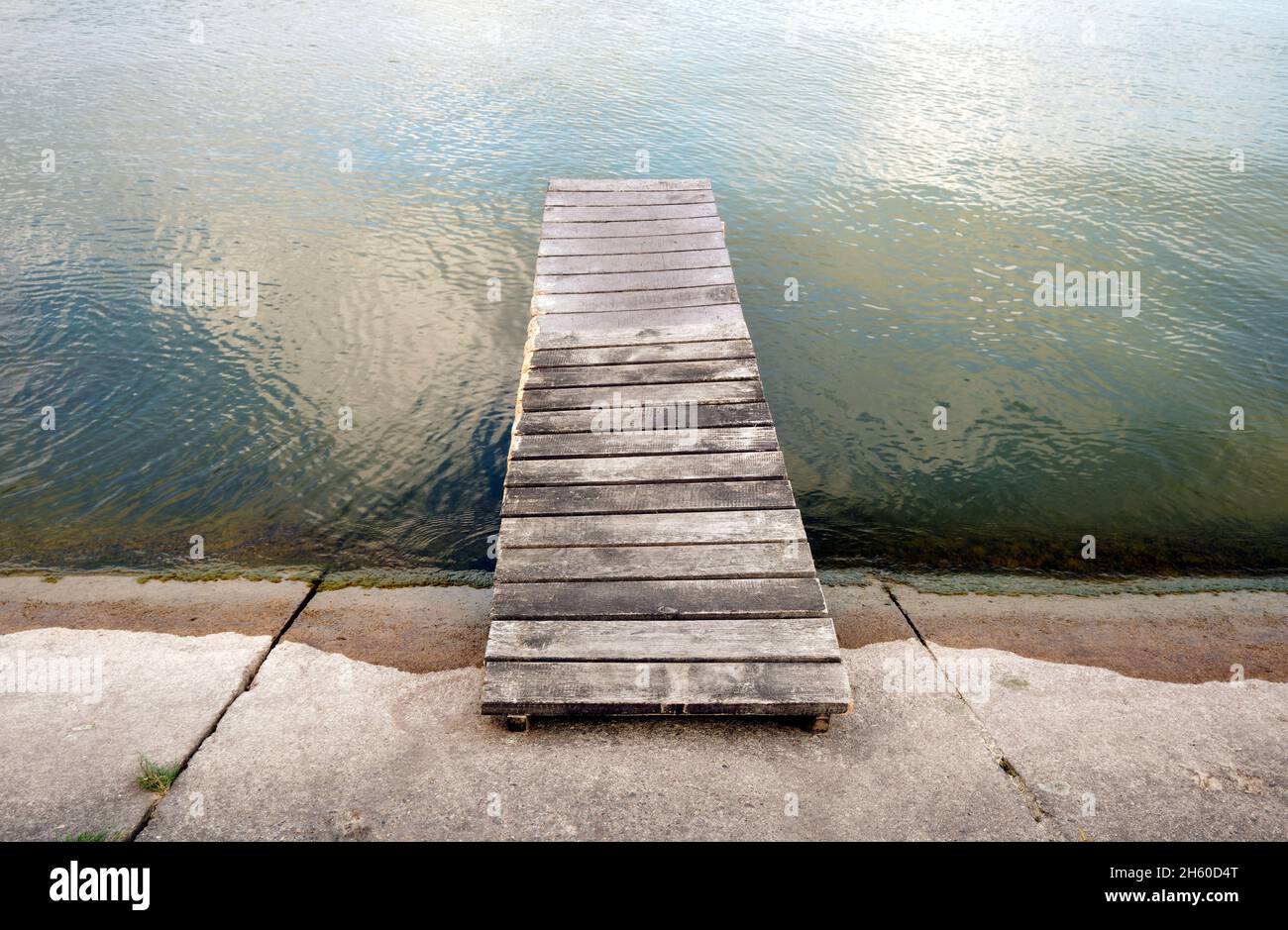 Kleiner hölzerner Pier am See, verlassene Anlegestelle in ruhigem Wasser Stockfoto