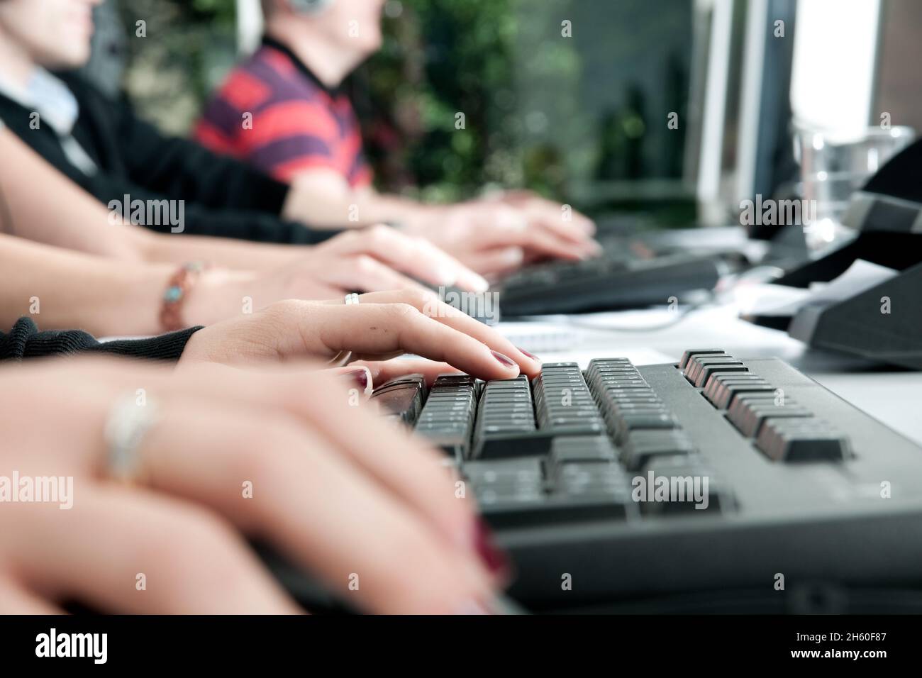 Ein Callcenter in Deutschland im Vordergrund steht auf Tastaturen. People are not to recognit. Stockfoto
