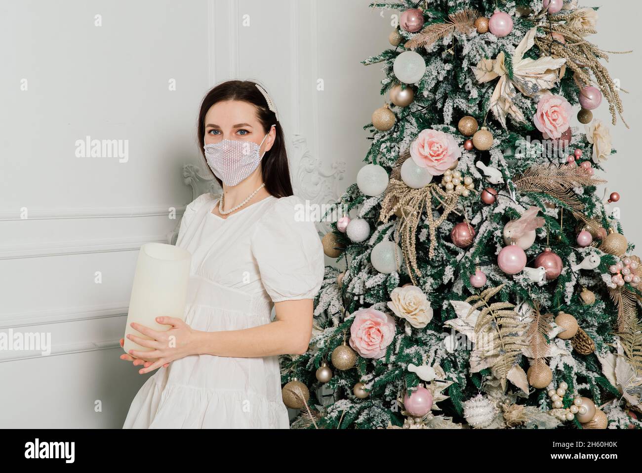 Junge schöne europäische Frau in einer medizinischen Maske mit Urlaub Geschenke zu Hause, Quarantäne Coronavirus. Stockfoto