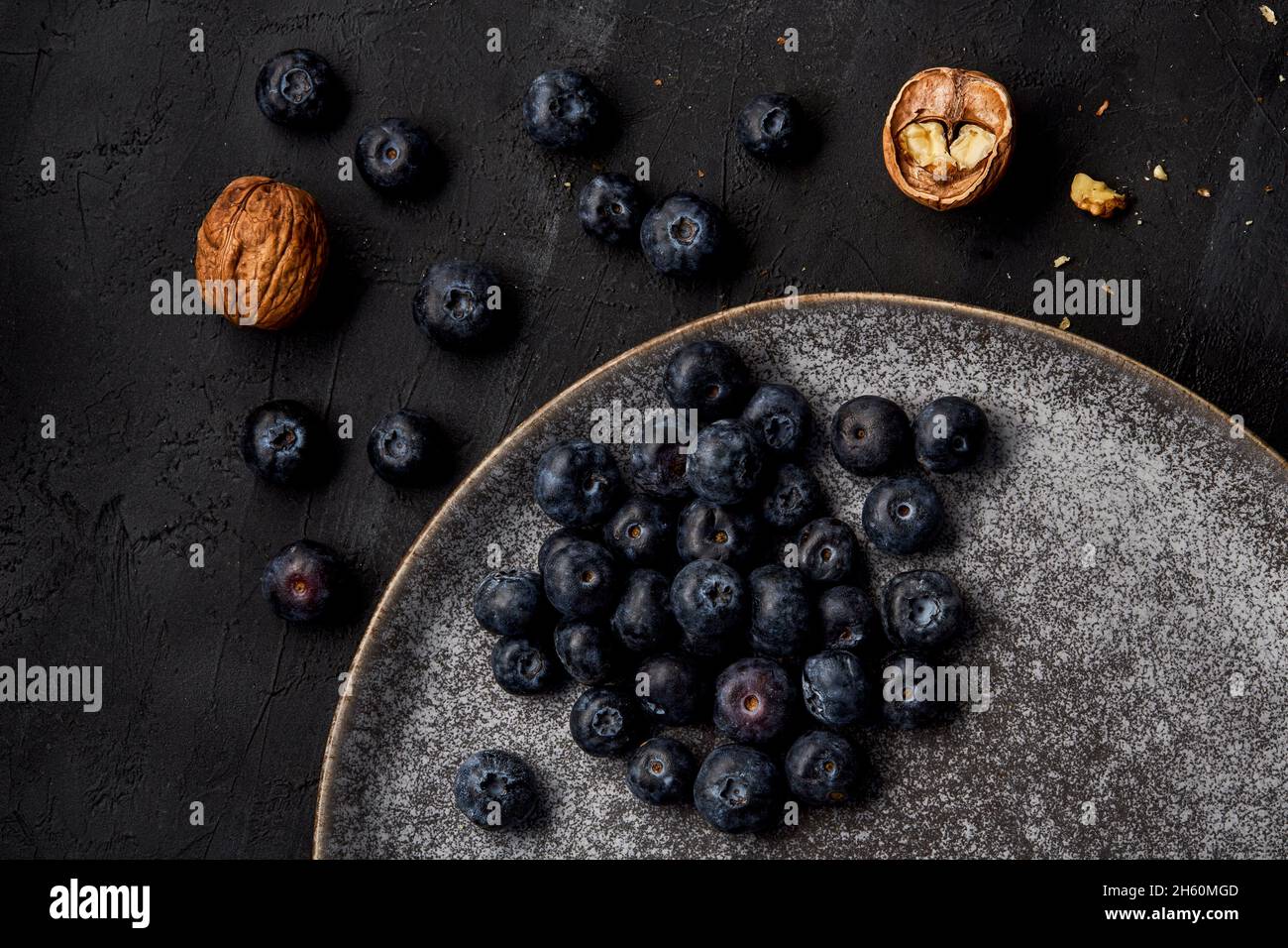 Anzeige von Blaubeeren und ganzen Nüssen auf einem Teller von oben gesehen. Stockfoto
