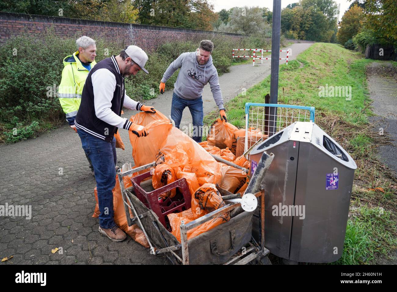 Ausgestattet mit Greifern und recycelbaren Mülltüten sammeln Freiwillige der Umweltorganisation KRAKE e.V. am linken Rheinufer vor der Leverkusenbrücke bei Köln Müll, 26. Oktober 2021 -- - ausgestattet mit Greifzangen und recycelbaren Müllsäcken sammeln Freiwillige der Umweltorganisation KRAKE e.V. das linksrheinische Ufer vor der Leverkusener Brücke bei Köln Unrat und Müll. Köln, 26.10.2021 Stockfoto