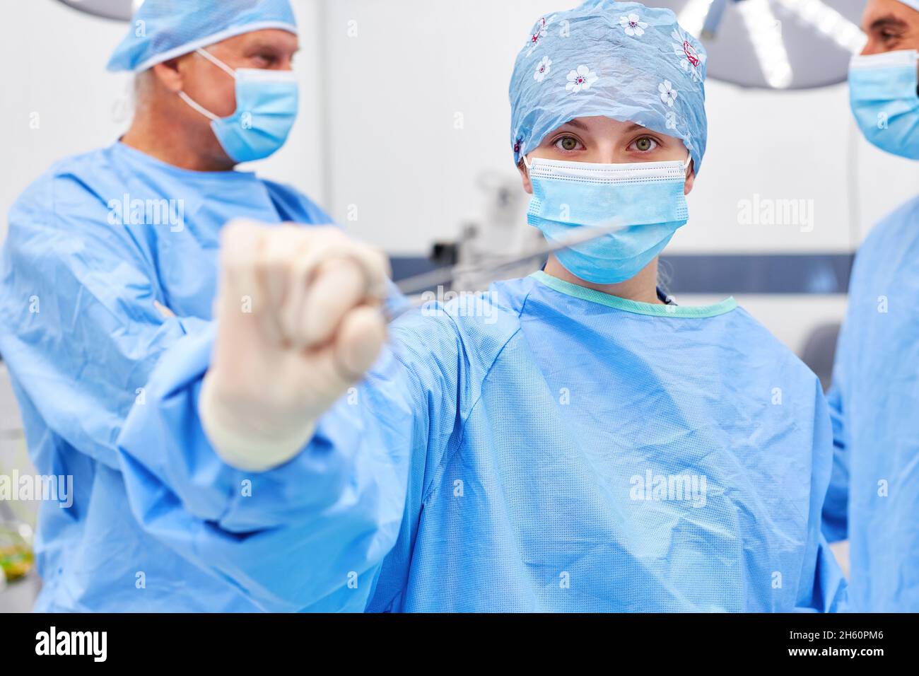 Junge Frau als chirurgische Krankenschwester oder Chirurg mit einer medizinischen Klemme vor der Operation Stockfoto