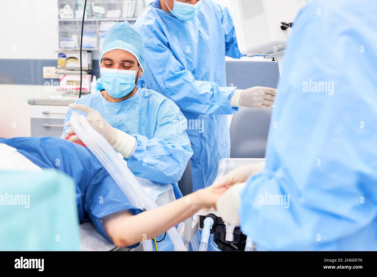 Anästhesist und Operationsteam geben der Patientin vor dem Operationssaal bei einer Notfalloperation Anästhesie Stockfoto