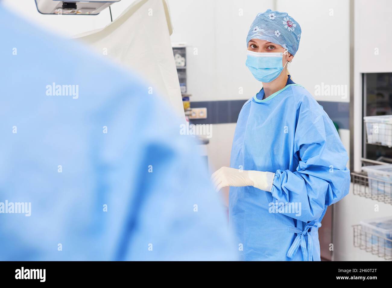 Junge Frau in Schutzkleidung als chirurgische Krankenschwester oder Arzt während eines Praktikums auf der Intensivstation Stockfoto