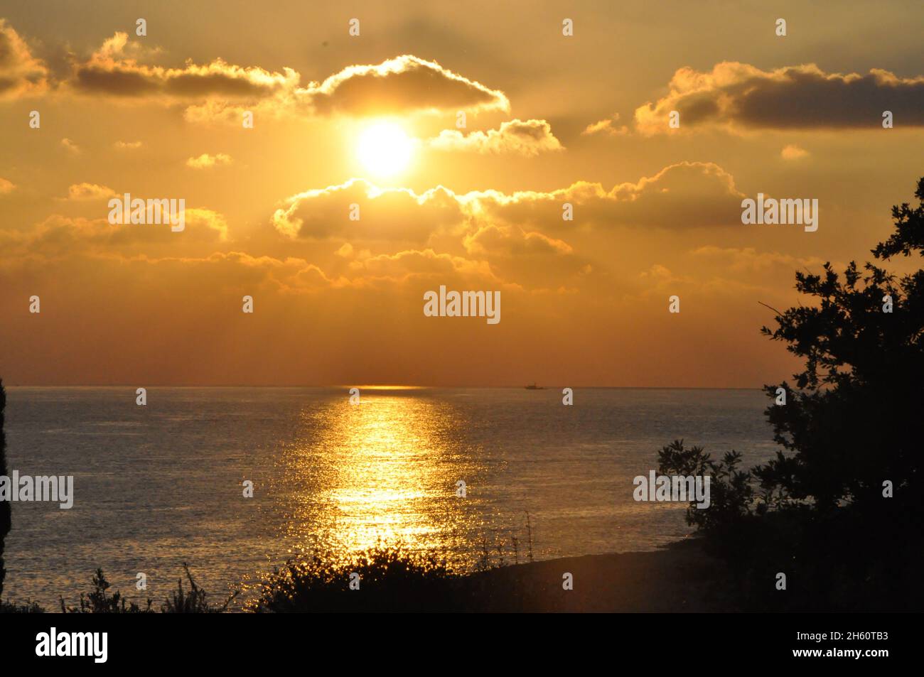 Sonnenstrahlen bei Sonnenuntergang über der Stadt am Meer.dramatischer roter Sonnenuntergang am Sommerabend über dem Berg in der Nähe von Rijeka Stadt, Kroatien.Dämmerung. Stockfoto