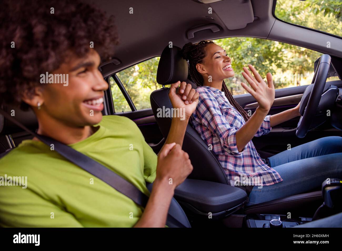 Foto-Portrait lächelndes Paar verbringt Zeit zusammen, um im Auto für den Urlaub zu fahren und Musik zu hören, lacht Stockfoto