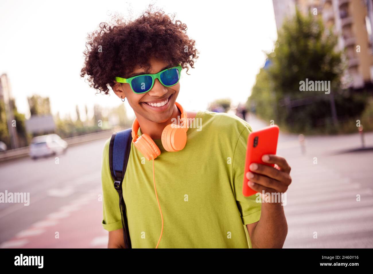 Portrait von attraktiven fröhlichen Kerl mit Gerät Blogging Musik hören genießen verbringen Freizeit sonnigen Tag Wochenende im Freien Stockfoto