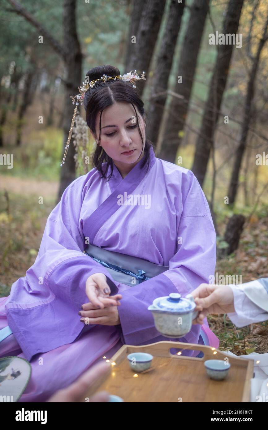 Kaukasische Frauen posieren im Herbst im Wald in chinesischen Hanfu-Kleidern. Konzept - Interesse an der traditionellen chinesischen Kultur Stockfoto