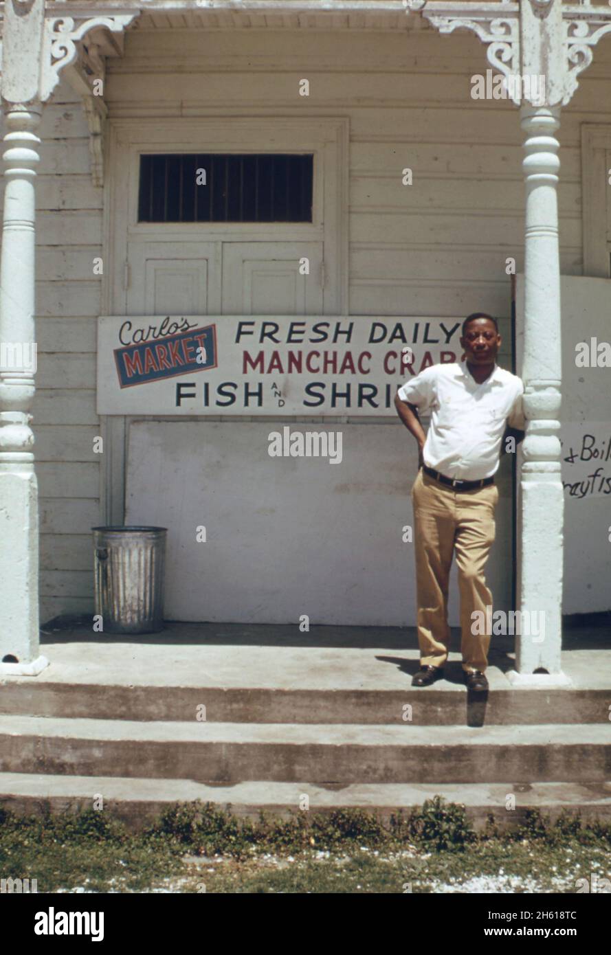 Mann, der vor einem Markt an der River Road (zwischen New Orleans und Baton Rouge) steht. Die meisten der hier verkauften Meeresfrüchte stammen aus Gewässern, die durch die Überschwemmung des Mississippi River Ca beeinträchtigt werden. April 1973 Stockfoto