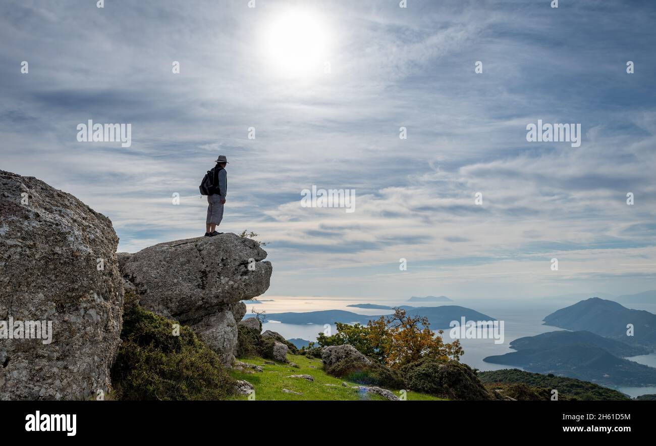 Ein Mann, der den Meerblick genießt, nachdem er auf den Gipfel eines Berges gewanderte. Stockfoto