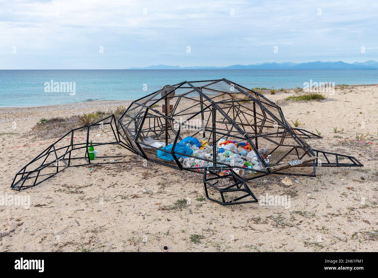 Lefkada. Griechenland-10.26.2021. Eine Skulptur einer Schildkröte an einem Strand mit Plastik im Inneren, die eine Umweltbotschaft der Plastikverschmutzung durch das Meer vermittelt. Stockfoto