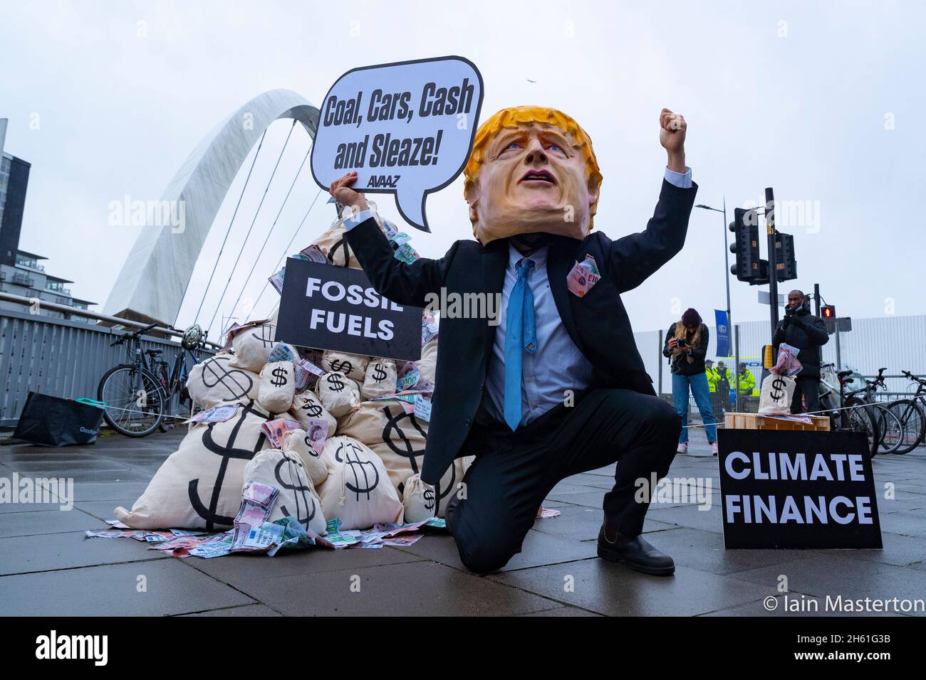 Glasgow, Schottland, Großbritannien. November 2021. Tag dreizehn und letzter Tag des UN-Klimagipfels COP26 in Glasgow. Boris Johnson Bildnis steht neben Säcken mit Geld, das bei einem Protest vor dem Veranstaltungsort der COP26 aus der Gewinnung fossiler Brennstoffe gewonnen wurde. Der Protest wurde von Avaaz organisiert, einer US-Wohltätigkeitsorganisation, die sich für den globalen Aktivismus im Klimawandel einsetzt. Iain Masterton/Alamy Live News. Stockfoto
