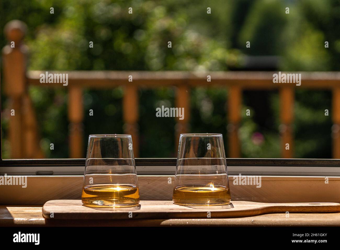Gläser Weißwein über grünem Gartenhintergrund, im Freien, Landhaus. Stockfoto