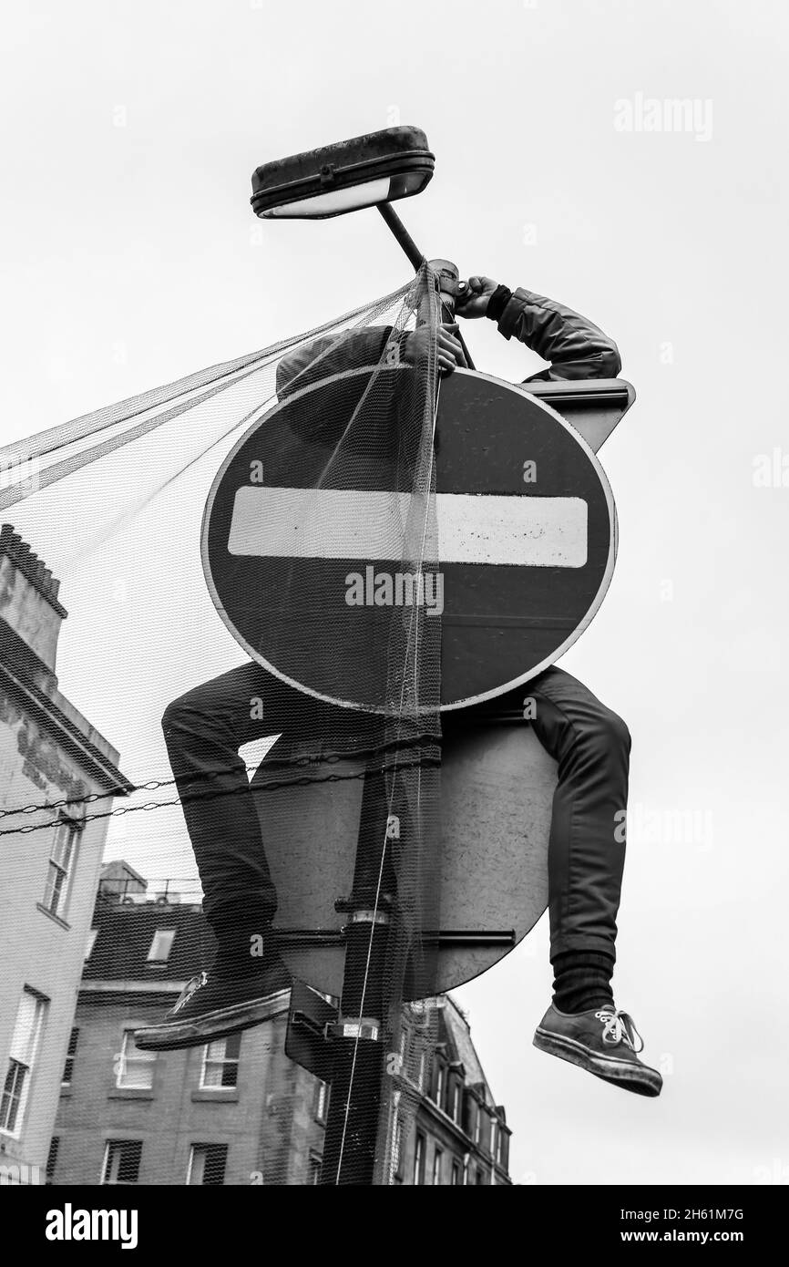 Ein Protestler hängt sein Banner während des Global Day of Action for Climate Justice march auf der COP26 in Glasgow 06.11.2021 an einem Straßenschild Stockfoto