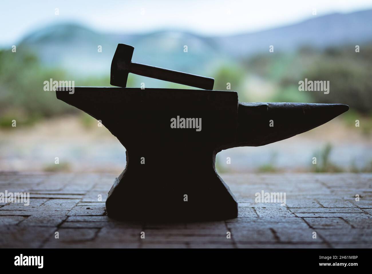 Hammer mit Holzgriff auf Amboss in der Metallindustrie gehalten Stockfoto