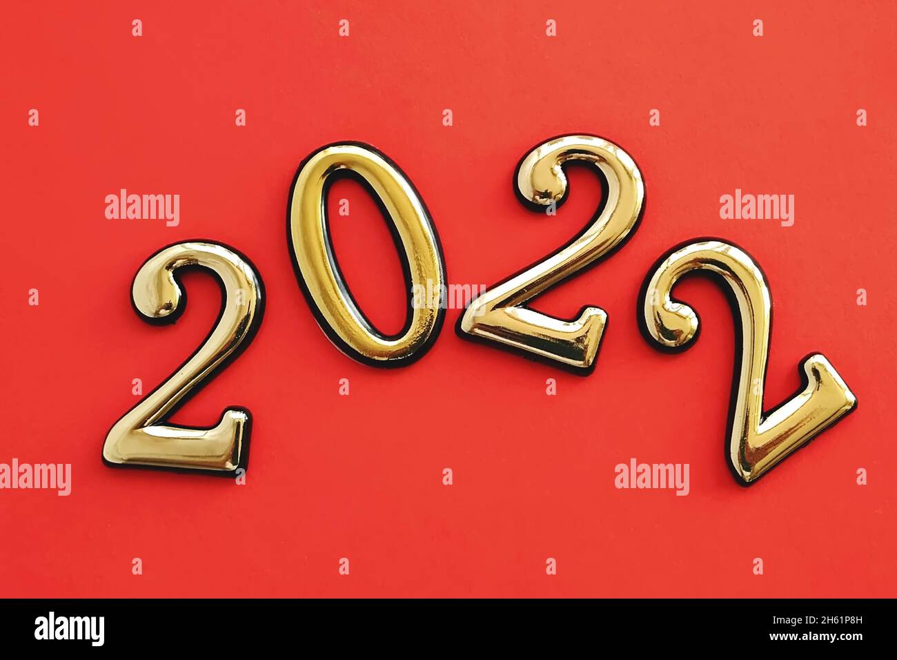Goldgelbe Zahlen 2022 auf rotem Hintergrund als Symbol des Kalenderwechsels zum neuen Jahr Stockfoto