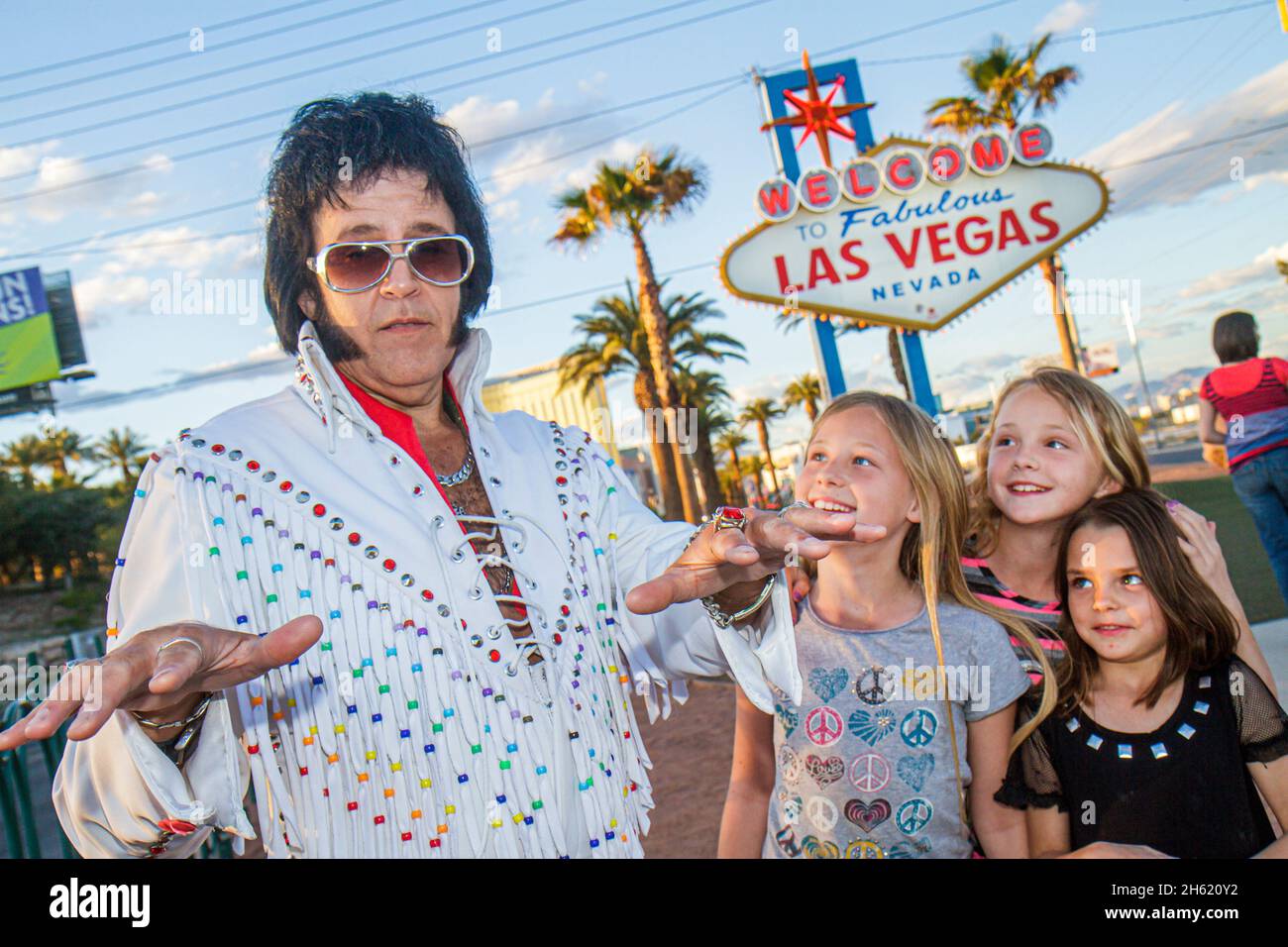 Las Vegas Nevada, The Strip, Willkommen im fabelhaften Las Vegas Schild historischer Mann, Elvis Presley Imitator Berühmtheit Look-alike Mädchen Kinder Stockfoto