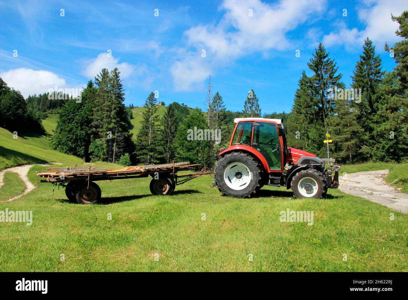 lindner geotrac 73,3300 cm–³, 3 Zylinder, bj. 2009,Traktor während der Heuernte,deutschland,bayern,oberbayern,werdenfelser Land,isartal,mittenwald,im Hintergrund der hohe kranzberg,wildensee,Buckelwiesen,Heuwagen Stockfoto