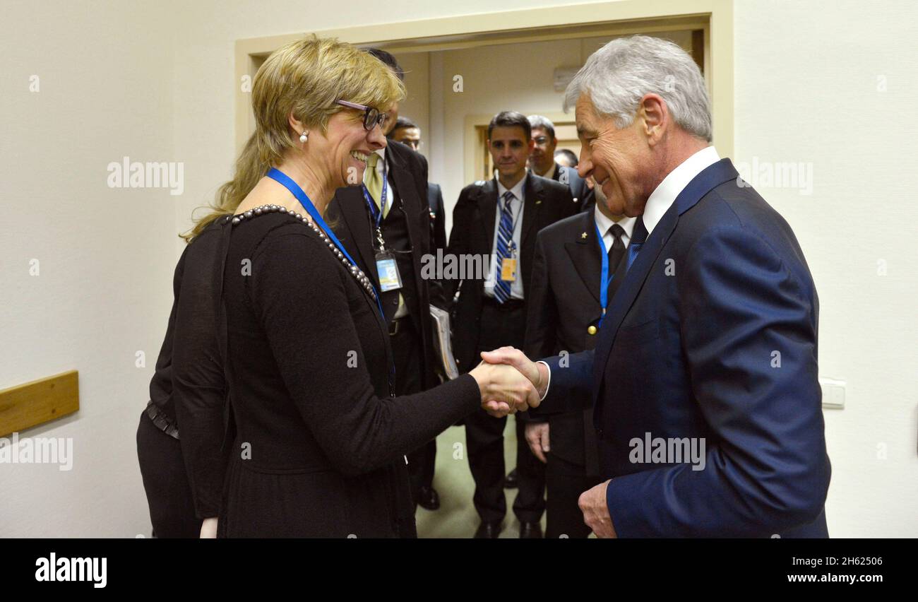 Verteidigungsminister Chuck Hagel begrüßt die italienische Verteidigungsministerin Roberta Pinotti zu einem Treffen im Rahmen der NATO-Verteidigungsministertagungen in Brüssel, Belgien, am 26. Februar 2014. Stockfoto