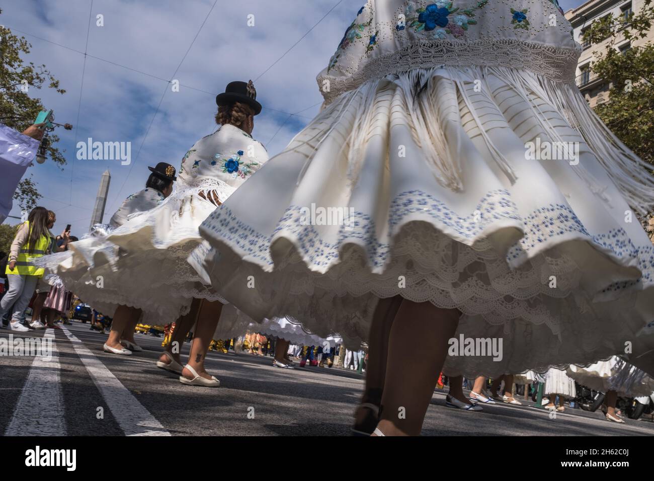 Nahaufnahme in Bewegung aus dem niedrigen Blickwinkel einer Performance einer weiblichen Gruppe bolivianischer Tänzer, die ihre traditionellen Hüte und Kostüme mit Wid tragen Stockfoto