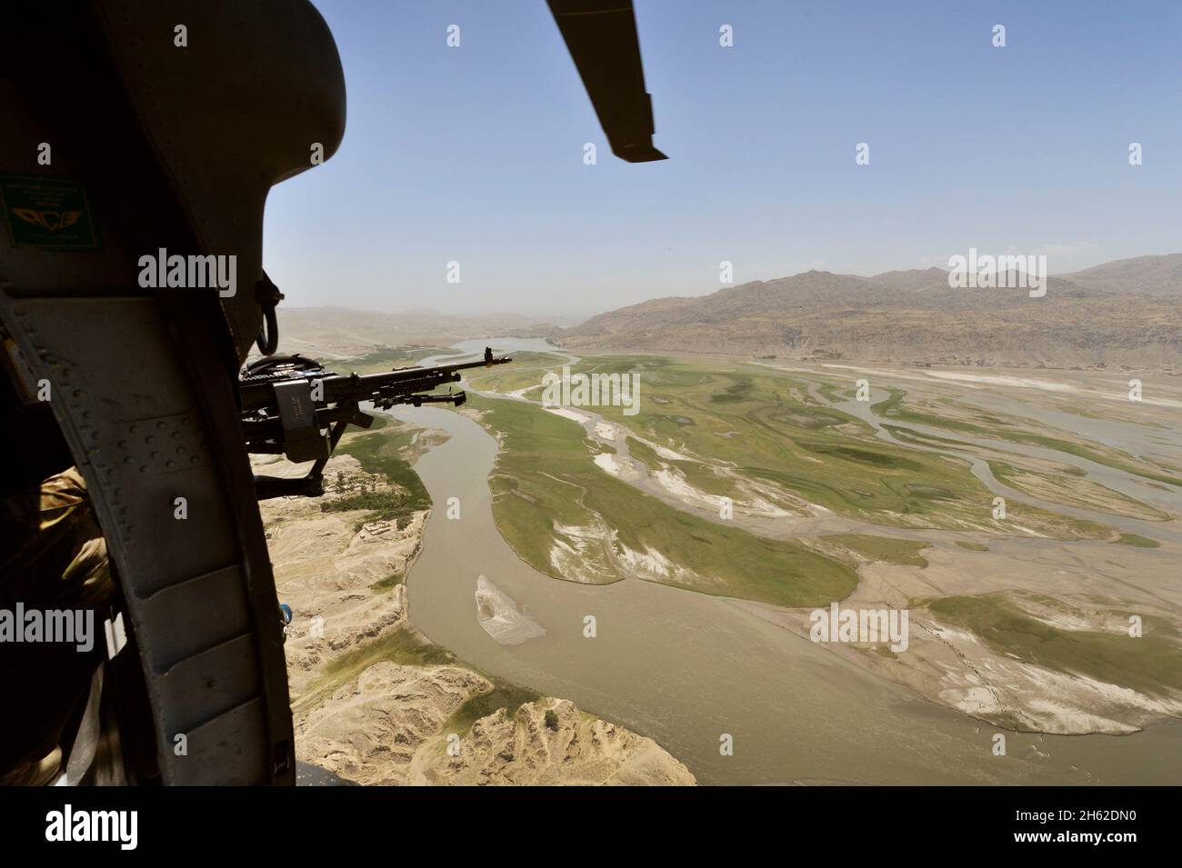 Ein Schütze wacht genau über die Landschaft unten, während Bob, stellvertretender Verteidigungsminister, mit dem Hubschrauber zur Bagram Air Base, Afghanistan, geflogen wird, 24. Juni 2014. Stockfoto