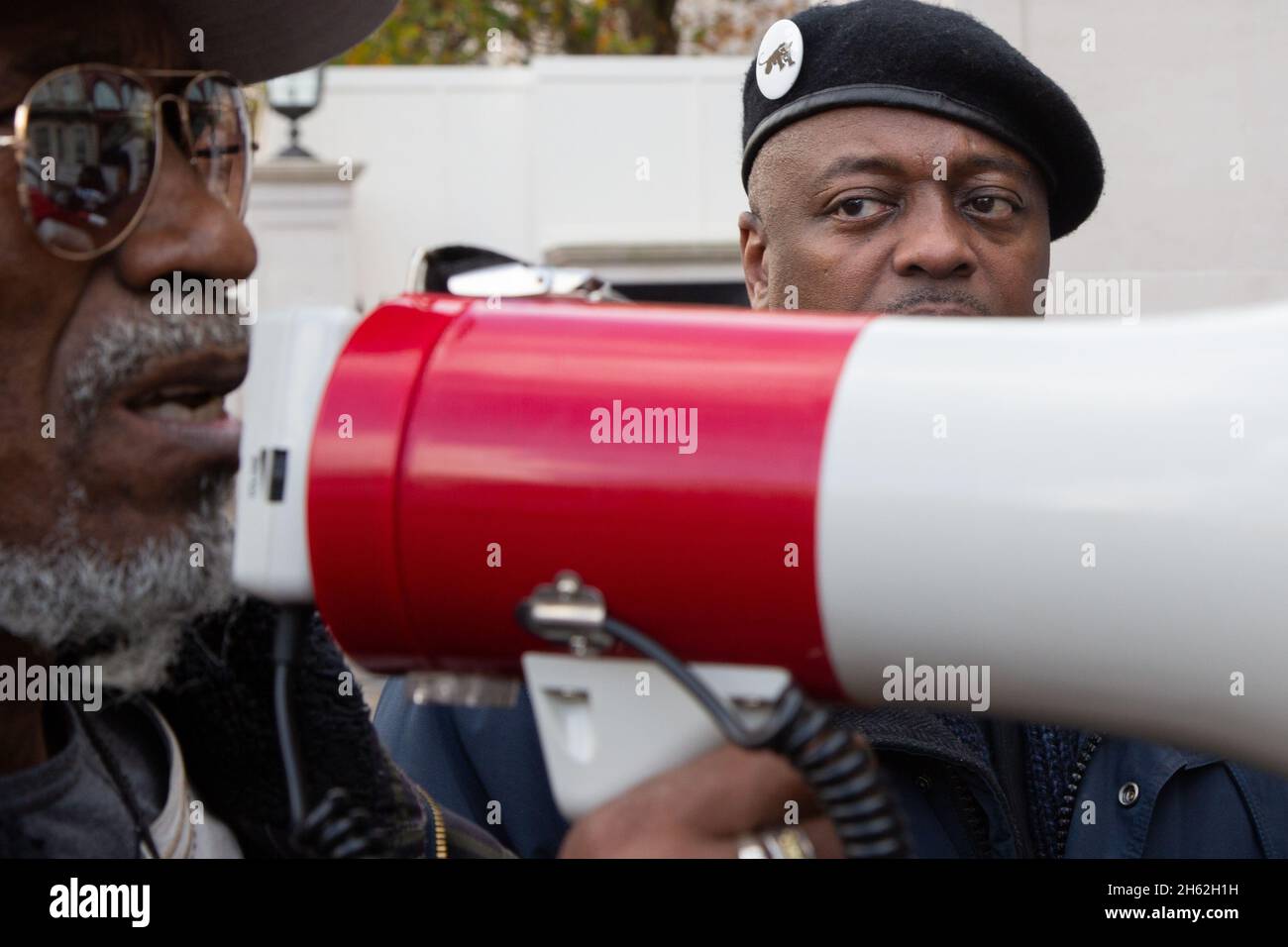 London, Großbritannien. November 2021. Während eines Anti-Sklaverei-Protests vor der libyschen Botschaft singt ein Protestler Parolen auf einem Megaphon. Menschenrechtsaktivisten protestierten vor der libyschen Botschaft, nachdem Berichte über afrikanische Migranten in lybischen Konzentrationslagern ausgehungert, geschlagen, gefoltert, vergewaltigt und in die Sklaverei gezwungen wurden. Kredit: SOPA Images Limited/Alamy Live Nachrichten Stockfoto