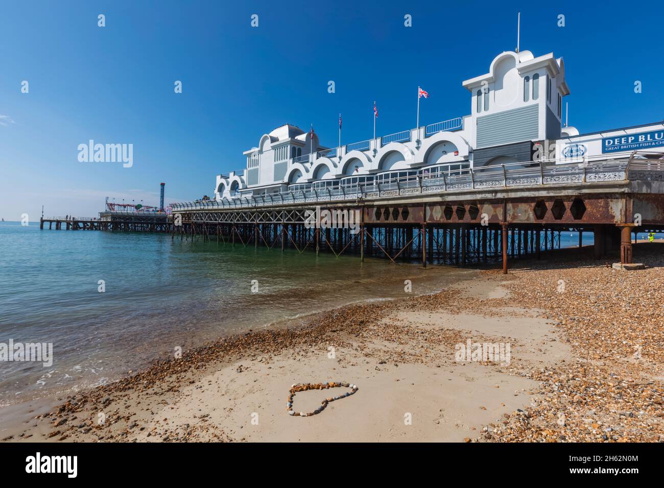 england, hampshire, portsmouth, southsea, herzförmiger Ring aus Kieselsteinen auf Sand vor dem southsea Pier Stockfoto