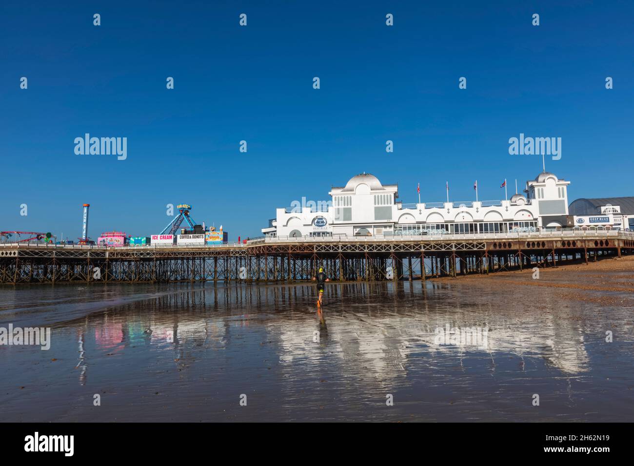 england, hampshire, portsmouth, southsea, Mann beim Joggen am Strand bei Ebbe vor dem southsea Pier Stockfoto