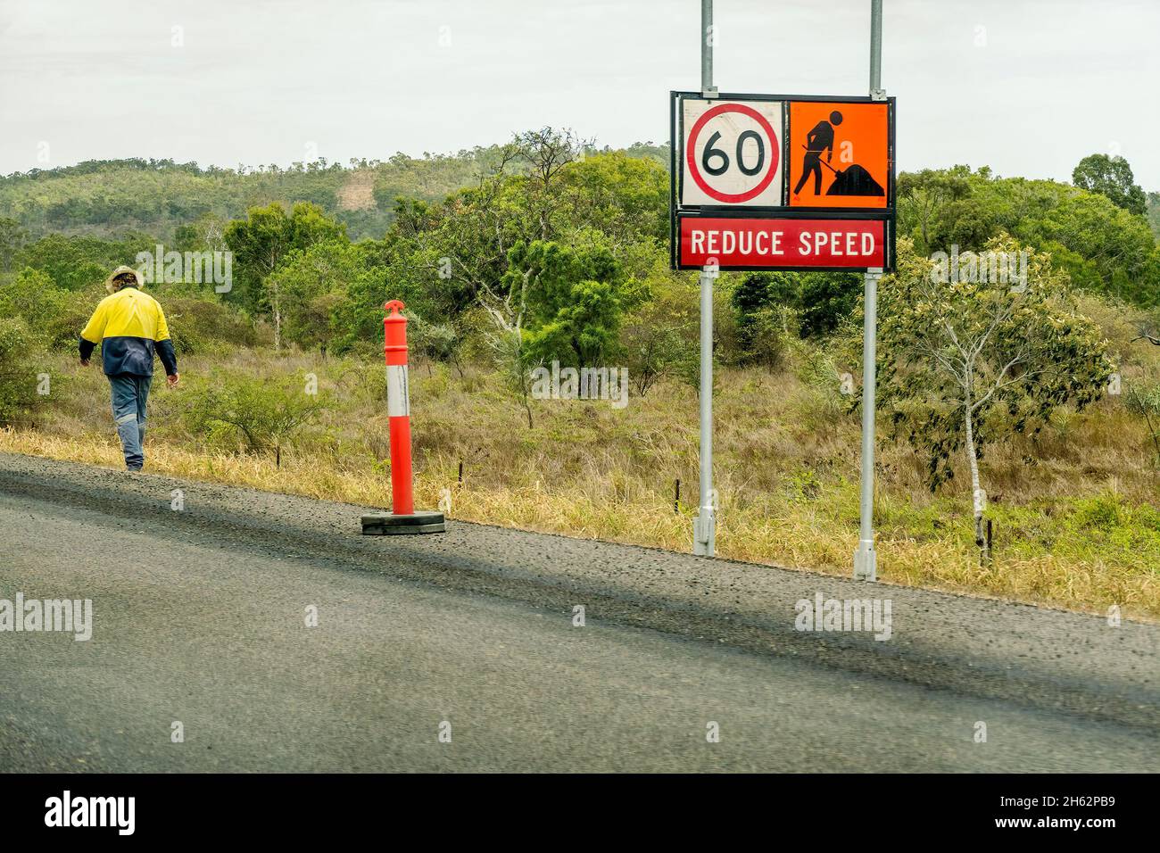 Bruce Highway Mackay nach Townsville, Queensland, Australien - November 2021: Reduzierung der Verkehrsbeschilderungen durch Bauarbeiten und Bauarbeiter, die in die Straße gehen Stockfoto