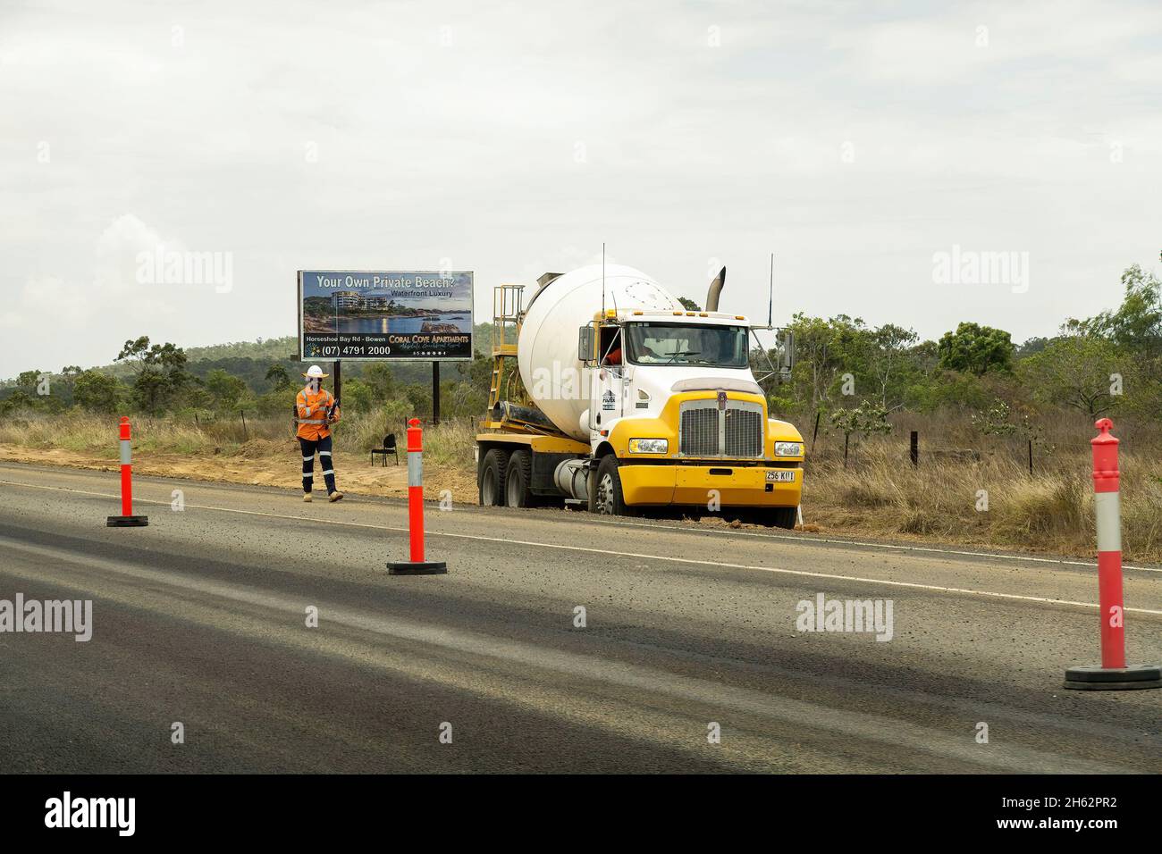 Bruce Highway Mackay nach Townsville, Queensland, Australien - November 2021: Bauarbeiter läuft neben Straßenarbeiten und ein LKW parkt vor Stockfoto