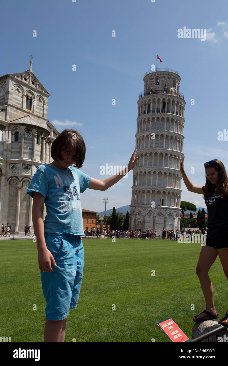 Ein typisches Touristenbild des schiefen Turms von pisa, toscany, italien, wo der Tourist aussieht, als würde er den Turm stützen. Stockfoto