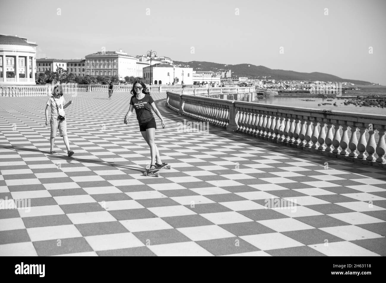 Skater Mädchen Skaten und Springen auf terrazza mascagni in livorno, italien. Es ist ein breites gewundenes belvedere zum Meer mit einer Pflasterfläche von 8700 qm wie ein Schachbrett und 4,100 Balustern Stockfoto