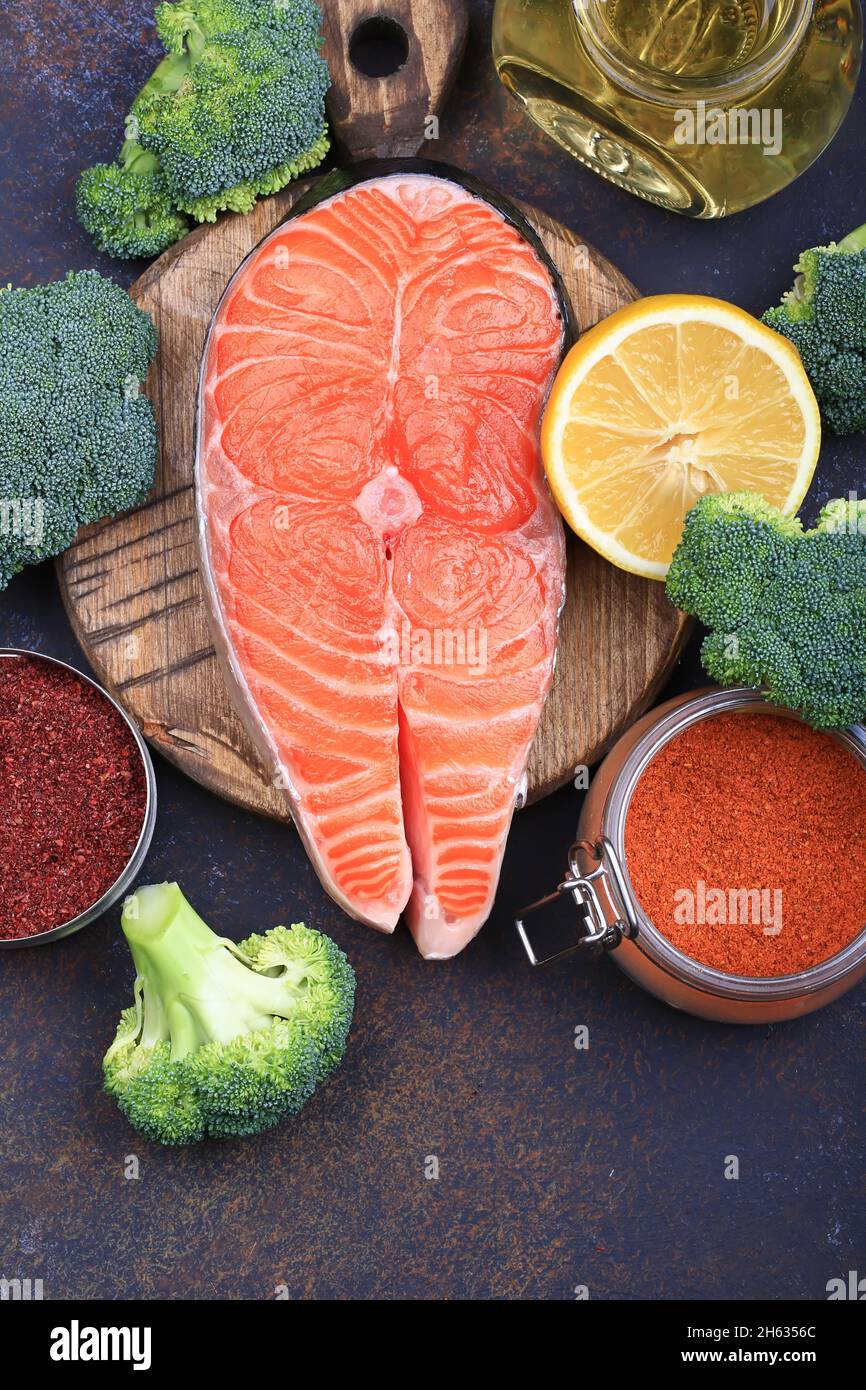Rohes rotes Fischsteak mit Brokkoli, Zitrone, Olivenöl und Gewürzen. Natürliches, gesundes Produkt Stockfoto