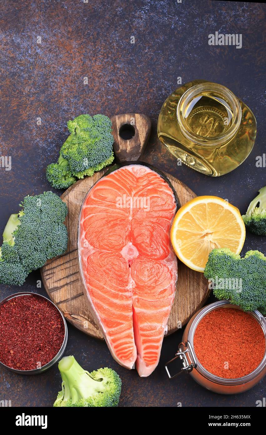 Rohes rotes Fischsteak mit Brokkoli, Zitrone, Olivenöl und Gewürzen. Natürliches, gesundes Produkt Stockfoto