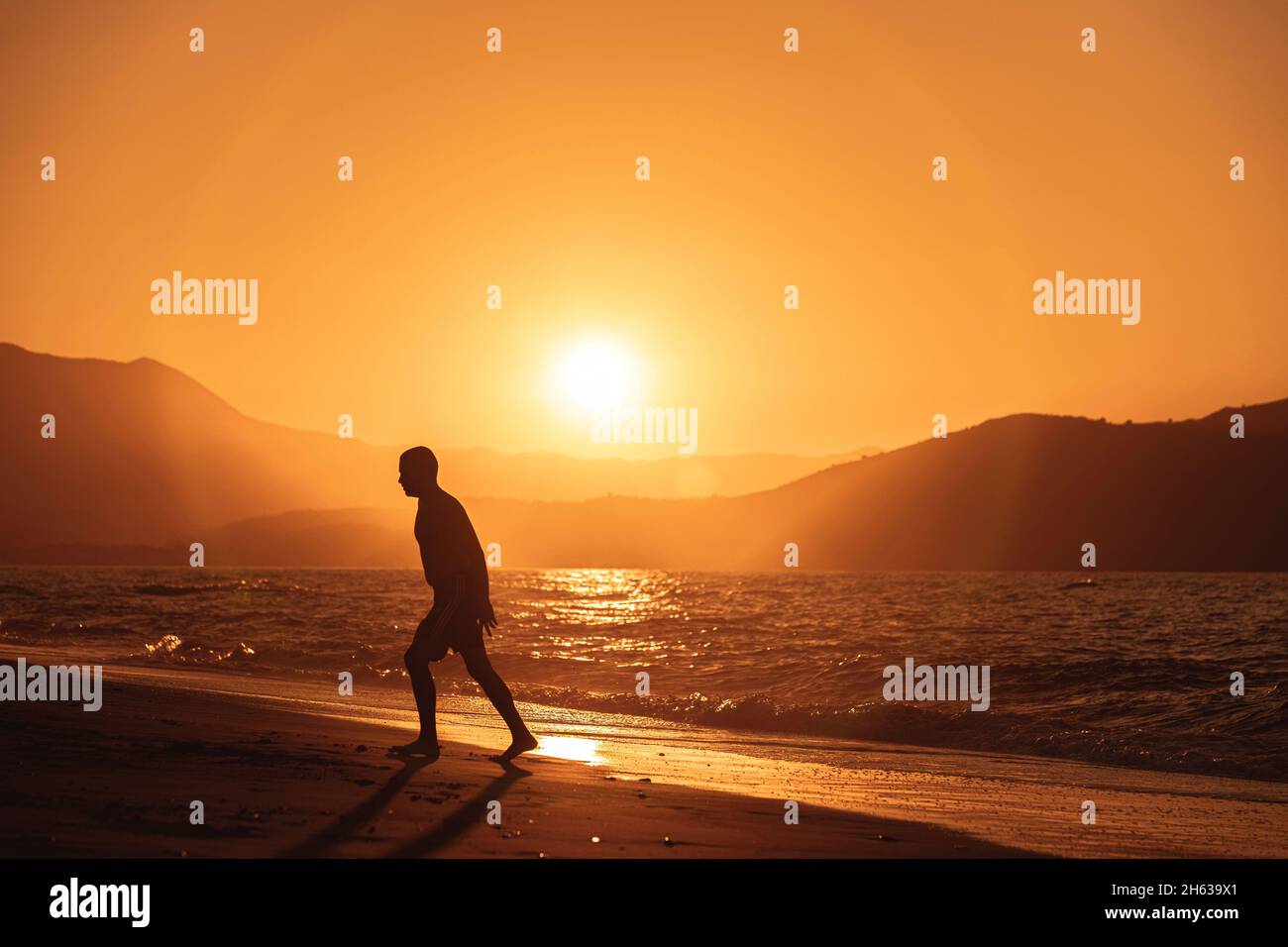 Menschen am Strand in Bewegung bei Sonnenuntergang Stockfoto