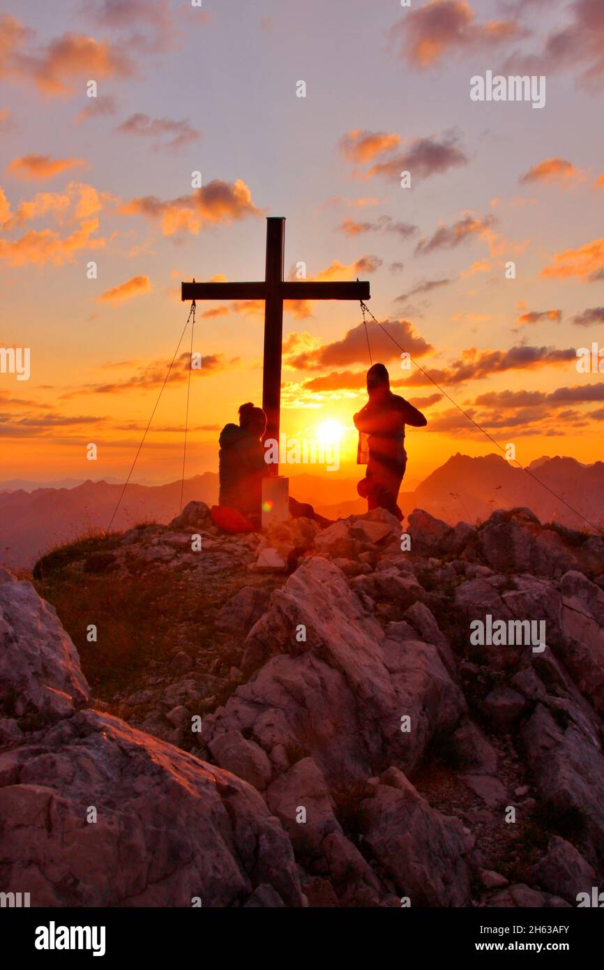 Zwei junge Frauen auf einer Wanderung,obere Wettersteinspitze,2.297 m,Gipfelkreuz,Sonne,Sonnenball,deutschland,bayern,oberbayern,werdenfelser Land,mittenwald,isartal Stockfoto