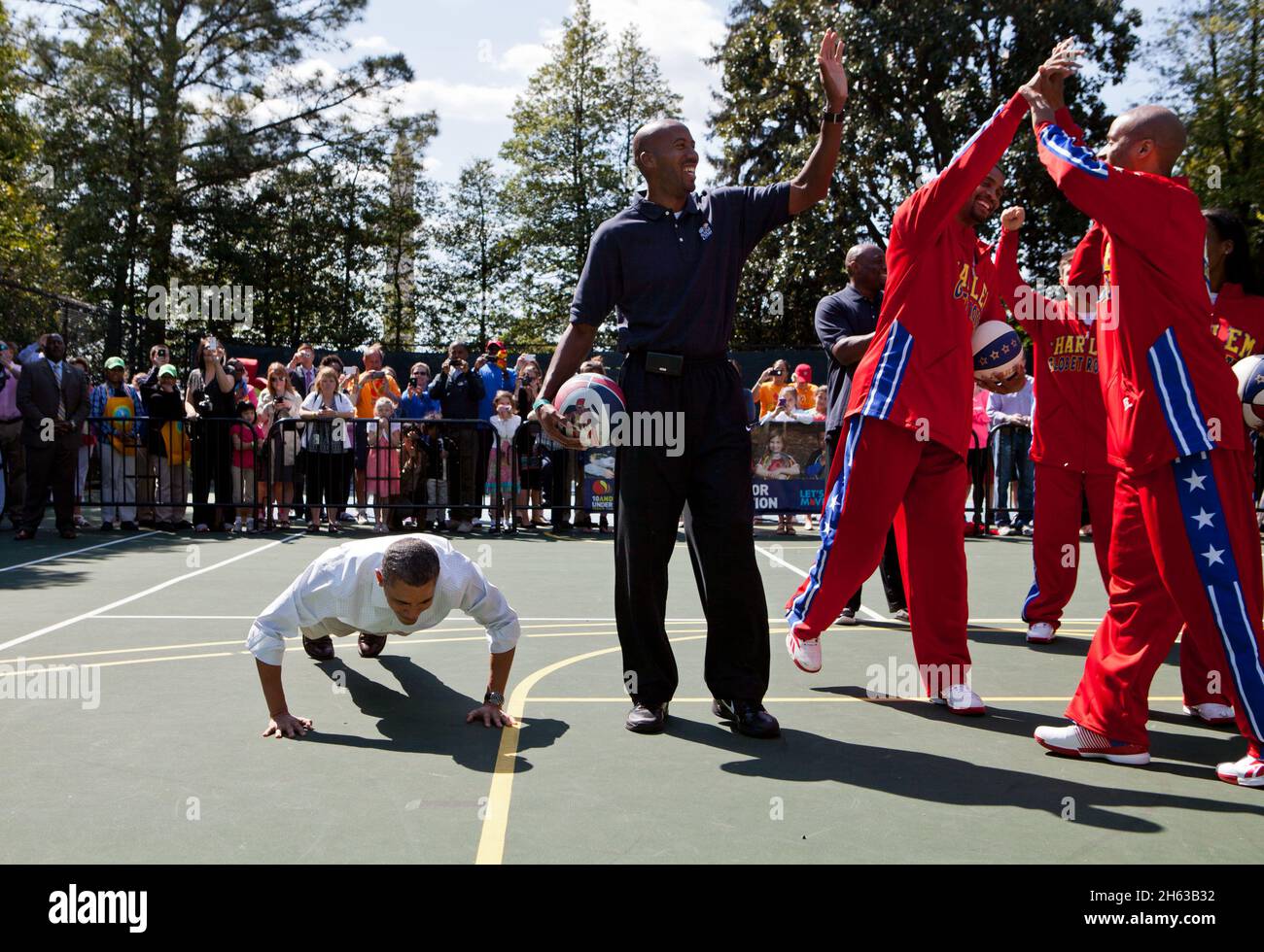 Präsident Barack Obama tut Liegestütze auf dem Weißen Haus Basketball Court, nachdem ein Mitglied der Harlem Globetrotters einen Schuss gemacht, 9. April 2012. Der Präsident nahm an "Shoot for Strength" Teil, einem Spiel, bei dem Kinder Liegestütze für jeden Basketball-Schuss der Profis machten, während der Ostereierrolle 2012 im Weißen Haus. Stockfoto