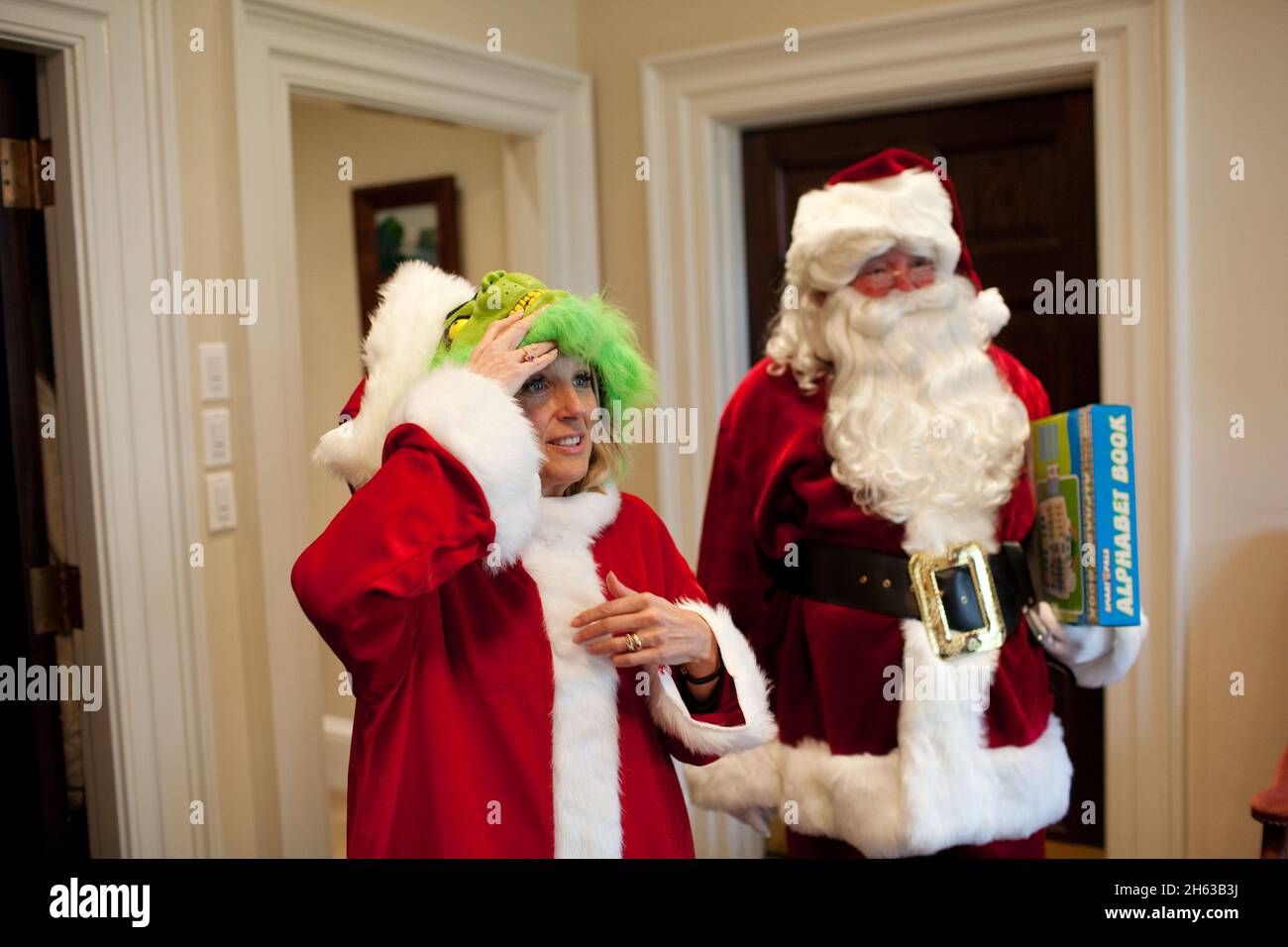 Dr. Jill Biden, verkleidet als der Grinch, Und der Vice President’s Trip Director Sam Myers, Sr., als Weihnachtsmann gekleidet, stoppen Sie durch die Outer Oval Office nach einem Empfang für Mitarbeiter, die in der Regierung des District of Columbia Child and Family Services 2009 Holiday Donation Drive, 14. Dezember 2009 teilgenommen. Stockfoto
