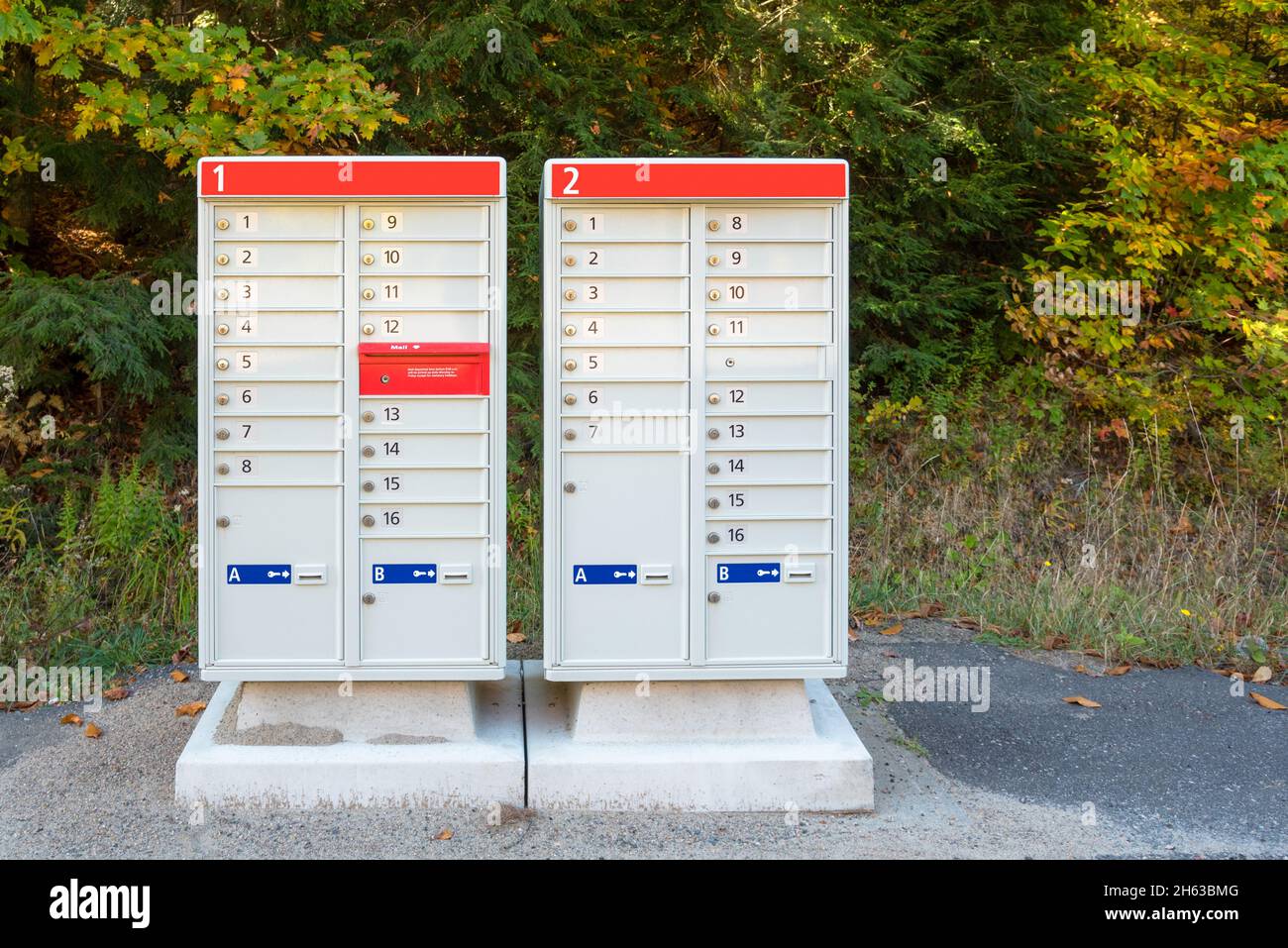 Briefkästen der Gemeinschaft entlang einer Straße am sonnigen Herbsttag Stockfoto