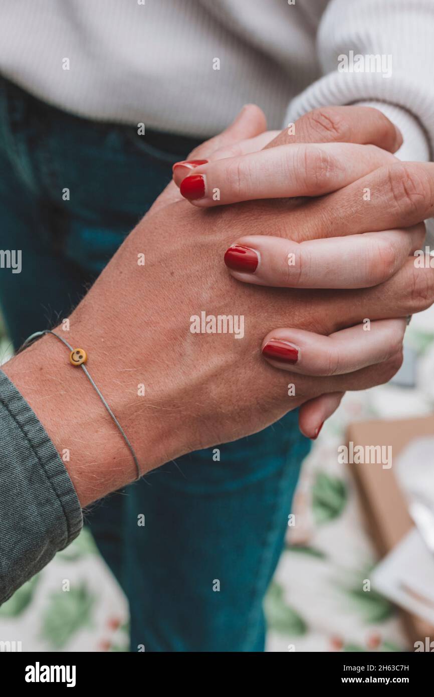 Junges Paar, Verlobungsschießen, Hände halten, Emoji-Armband Stockfoto