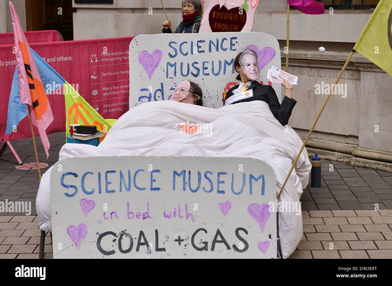 London, Großbritannien. November 2021. Aktivisten, die als Direktor des Science Museums, Ian Blatchford, und Shell-CEO Ben van Beurden gekleidet sind, liegen während der Demonstration auf einem Bett mit gefälschtem Geld.Aktivisten des Extinction Rebellion protestierten gegenüber dem Science Museum in South Kensington gegen das Sponsoring des Museums durch die fossilen Energiekonzerne Shell und Adani. Kredit: SOPA Images Limited/Alamy Live Nachrichten Stockfoto